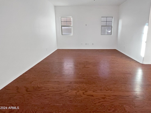 unfurnished room with dark wood-type flooring