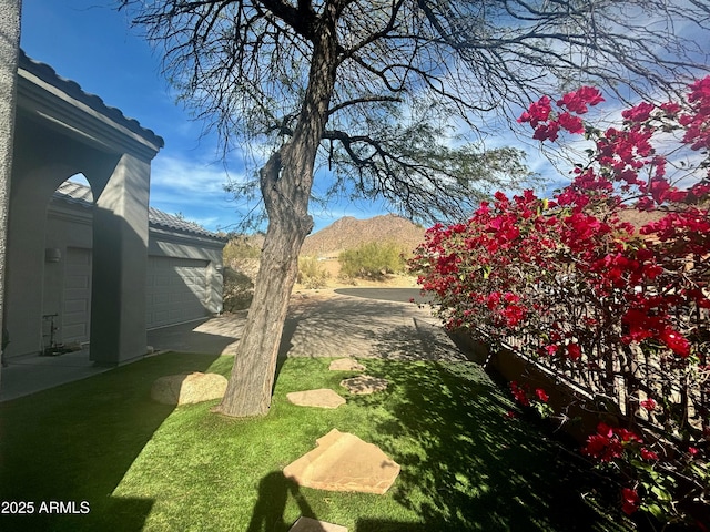 view of yard with a garage and a mountain view