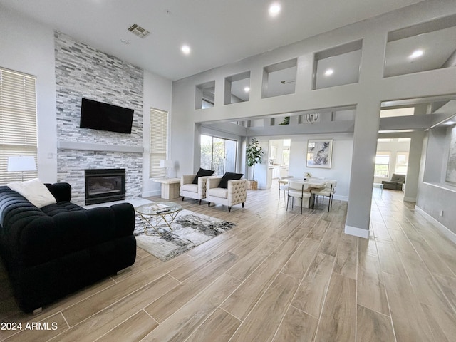 living room with a towering ceiling and a fireplace