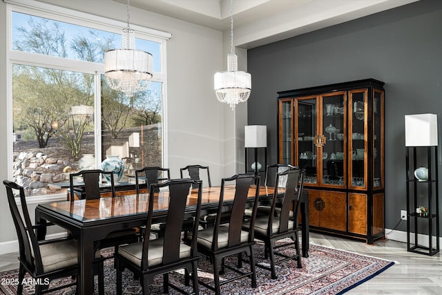 dining area with an inviting chandelier and light parquet floors