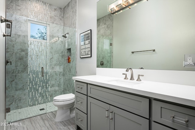 bathroom with an enclosed shower, vanity, and toilet