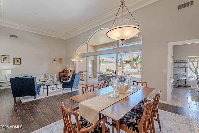 dining space with wood finished floors, ornamental molding, baseboards, and visible vents