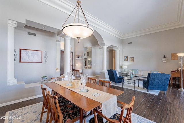 dining area featuring baseboards, decorative columns, visible vents, and wood finished floors