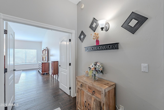 hallway featuring dark wood-type flooring and baseboards