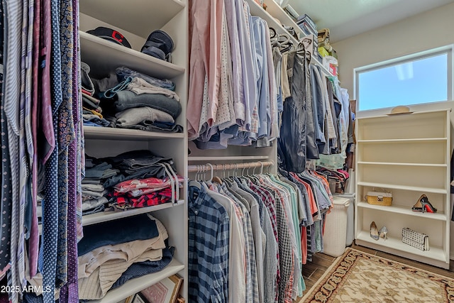 walk in closet with wood finished floors