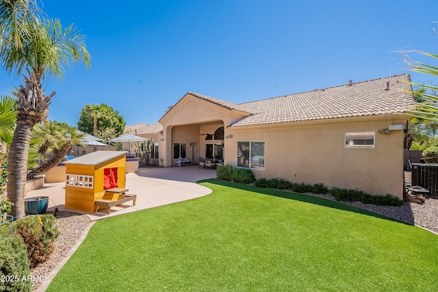 rear view of house with a patio area, central air condition unit, stucco siding, fence, and a yard