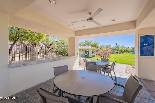 view of patio / terrace with fence, outdoor dining area, and ceiling fan