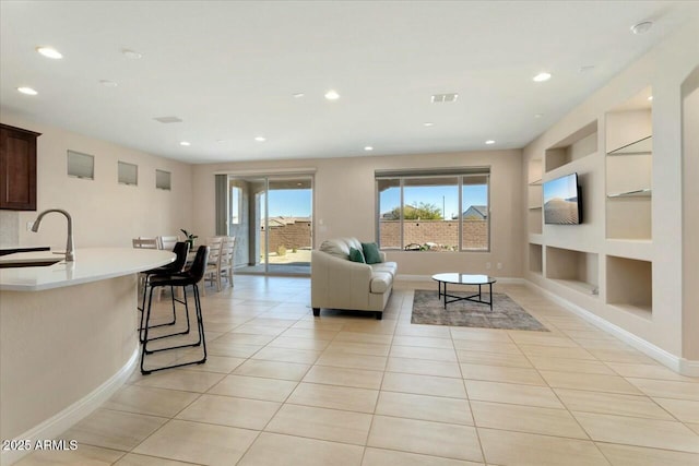 tiled living room with built in shelves and sink