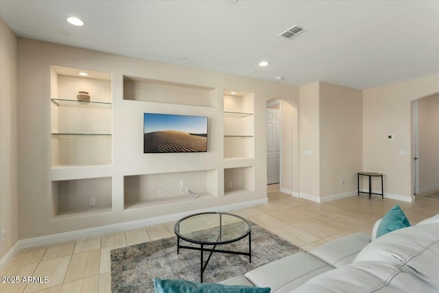 living room featuring built in features and light tile patterned floors