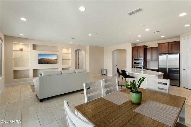 dining space featuring built in shelves, sink, and light tile patterned floors