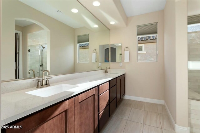 bathroom featuring tile patterned floors, vanity, and a shower with door