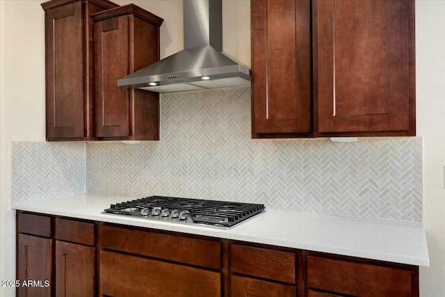 kitchen featuring stainless steel gas stovetop, wall chimney exhaust hood, and decorative backsplash