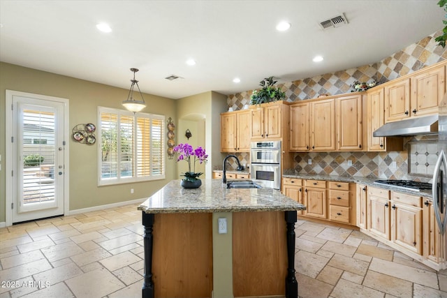 kitchen with stone tile floors, a sink, visible vents, baseboards, and appliances with stainless steel finishes