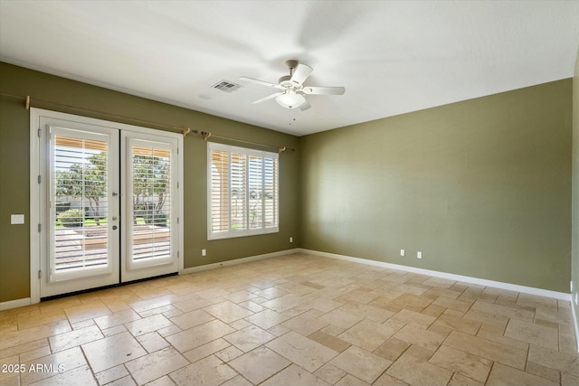 empty room featuring stone tile floors, a ceiling fan, visible vents, baseboards, and french doors