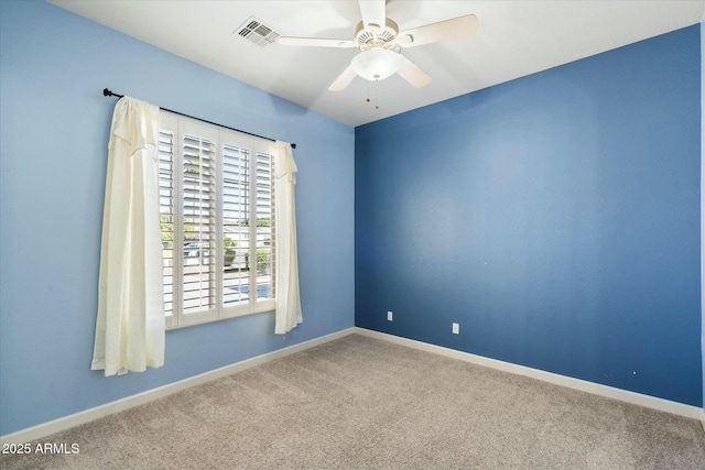 carpeted empty room with baseboards, visible vents, and a ceiling fan