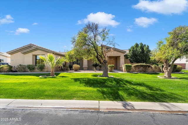 view of front of property featuring a front yard, a tile roof, and stucco siding