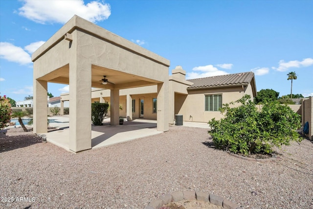 back of house with a ceiling fan, a tiled roof, a patio area, central AC, and stucco siding