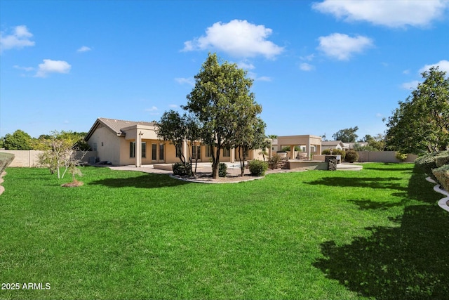 back of property with a fenced backyard, a lawn, and a patio