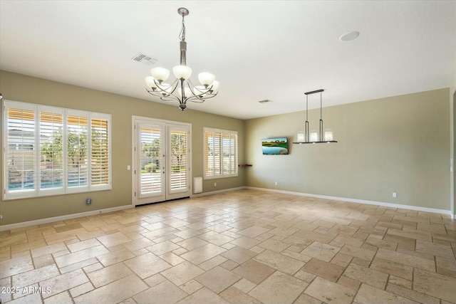 empty room featuring french doors, stone tile floors, visible vents, an inviting chandelier, and baseboards