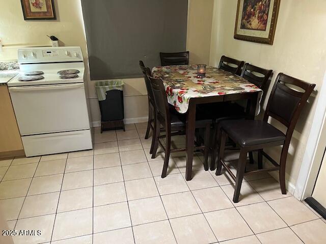 dining space with baseboards and light tile patterned flooring