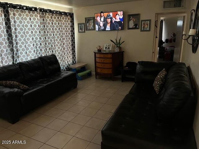 living area with visible vents and light tile patterned flooring