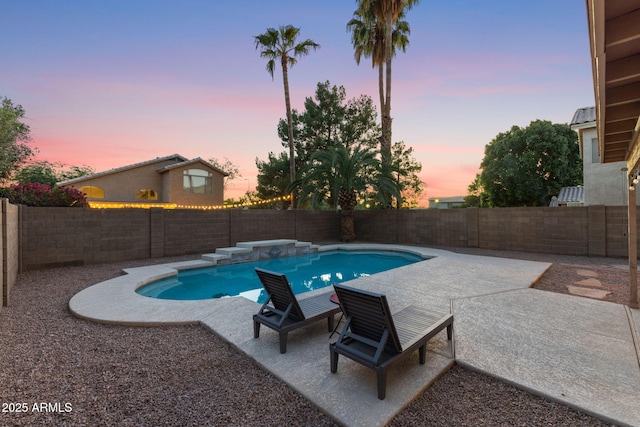 pool at dusk with a patio area