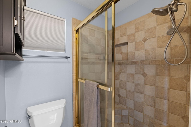 bathroom featuring toilet and a shower with door