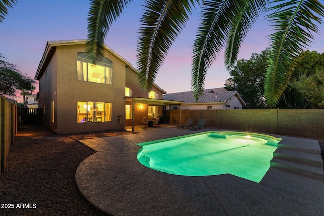 pool at dusk featuring a patio area