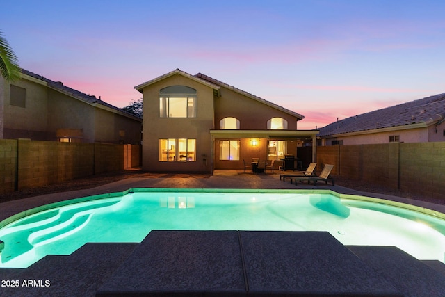 pool at dusk featuring a patio