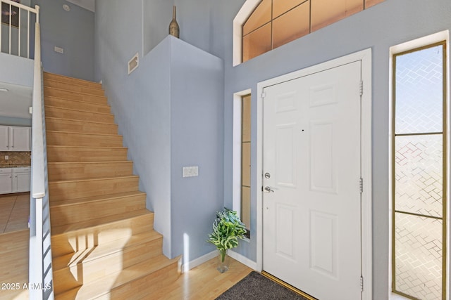 entryway featuring light hardwood / wood-style floors and a high ceiling