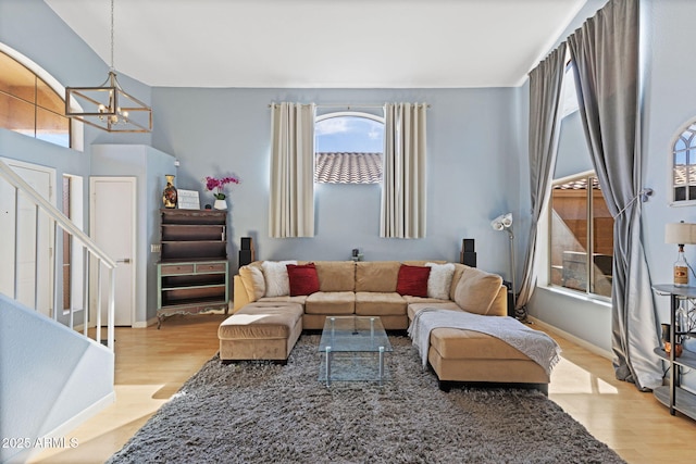 living room featuring plenty of natural light, light wood-type flooring, and a notable chandelier