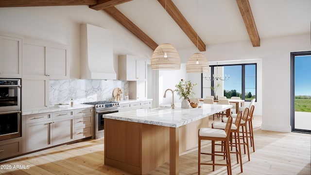 kitchen with light stone counters, appliances with stainless steel finishes, wall chimney range hood, backsplash, and a kitchen bar