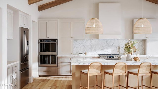 kitchen featuring light stone countertops, tasteful backsplash, a kitchen bar, and appliances with stainless steel finishes