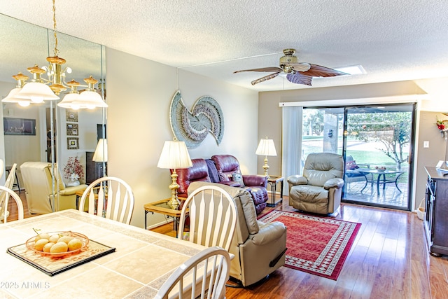 dining area with ceiling fan, wood-type flooring, and a textured ceiling