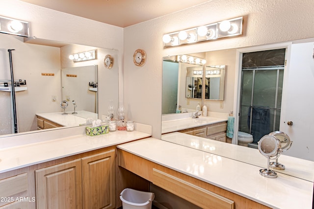 bathroom featuring vanity, an enclosed shower, and toilet