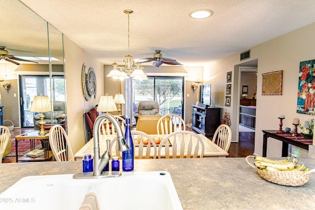 dining room with sink, a textured ceiling, plenty of natural light, and ceiling fan