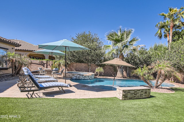 view of pool featuring a pool with connected hot tub, a patio area, a fenced backyard, and a yard