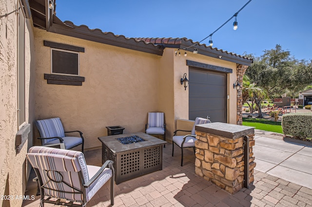 view of patio / terrace featuring a fire pit and a garage