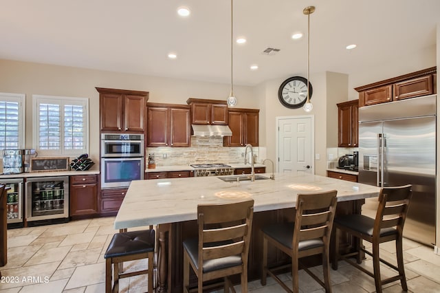 kitchen featuring visible vents, wine cooler, stainless steel appliances, under cabinet range hood, and a sink