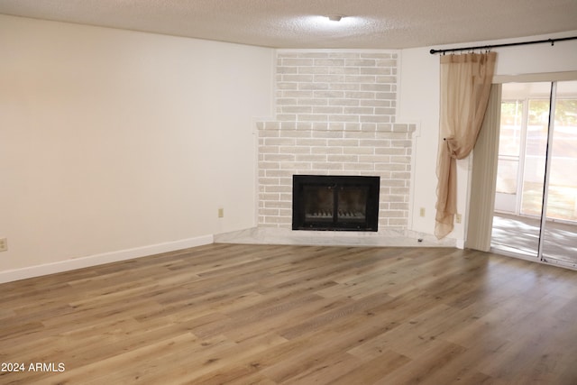 unfurnished living room featuring a textured ceiling, a fireplace, and hardwood / wood-style flooring