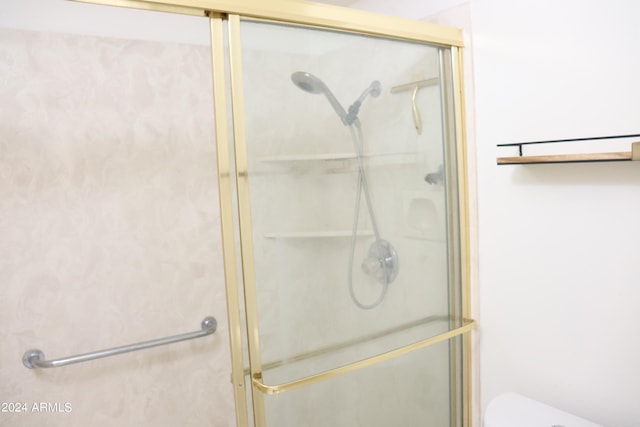 bathroom with toilet and a shower with shower door