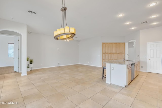 kitchen featuring sink, decorative light fixtures, light brown cabinets, dishwasher, and light stone countertops