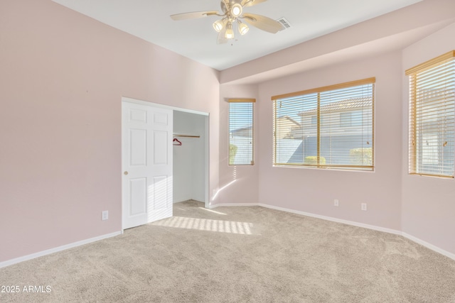 carpeted empty room with ceiling fan and plenty of natural light