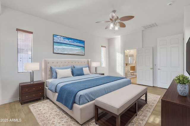 bedroom with ensuite bathroom, ceiling fan, and light wood-type flooring