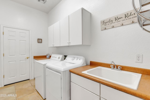 clothes washing area with independent washer and dryer, cabinets, sink, and light tile patterned floors