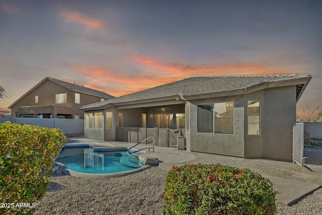 pool at dusk featuring a patio area