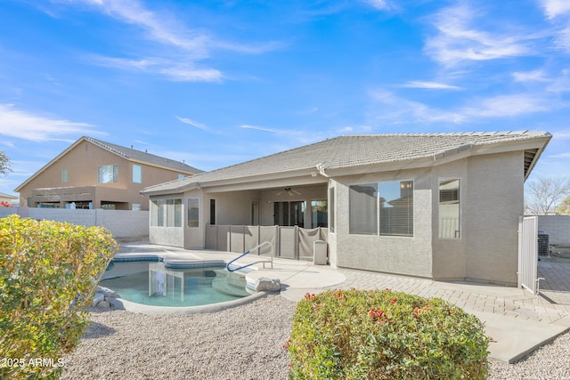 back of house featuring a fenced in pool, ceiling fan, and a patio area