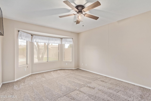 empty room featuring carpet floors, ceiling fan, and baseboards