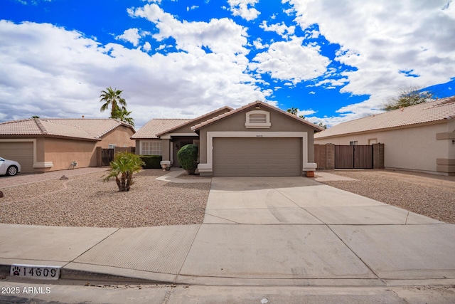 view of front of house featuring an attached garage, fence, concrete driveway, a tiled roof, and stucco siding