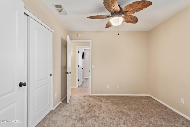 unfurnished bedroom featuring a closet, light carpet, visible vents, and baseboards